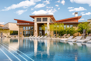 White clubhouse overlooking apartment pool area