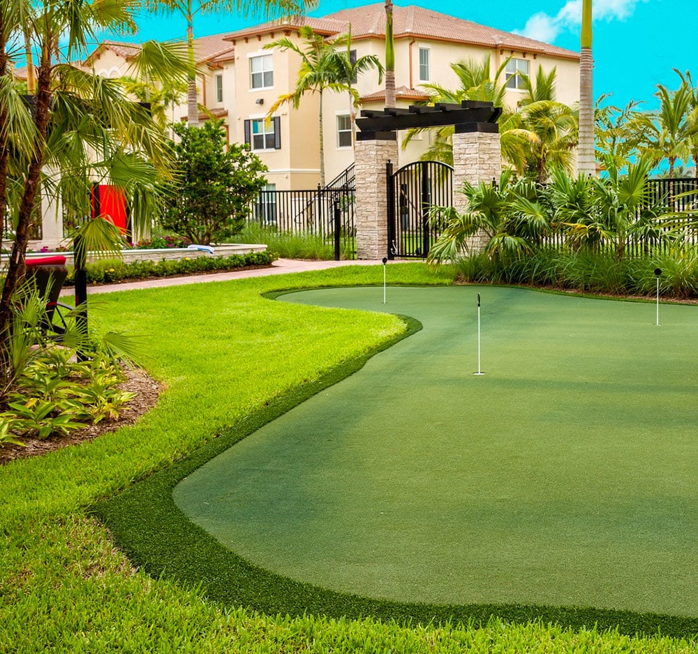 Tan apartment overlooking putting green with palm trees