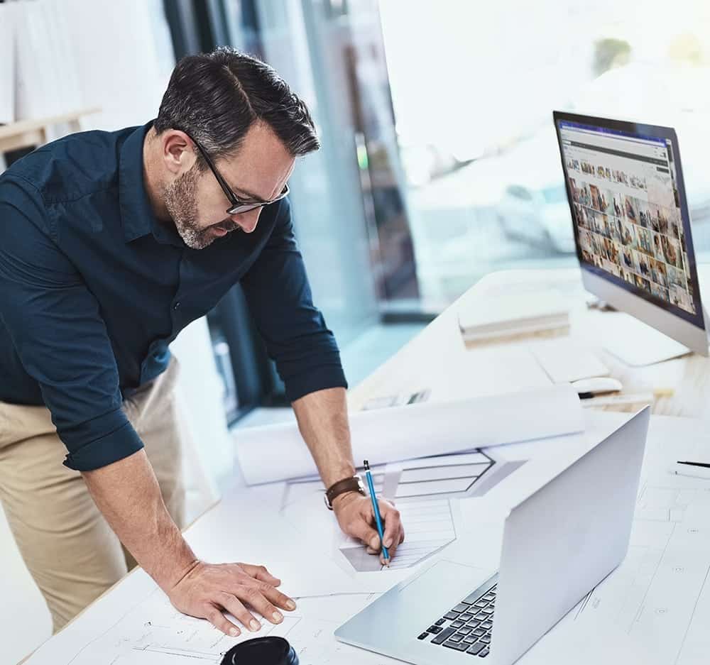A man with glasses looks over paperwork