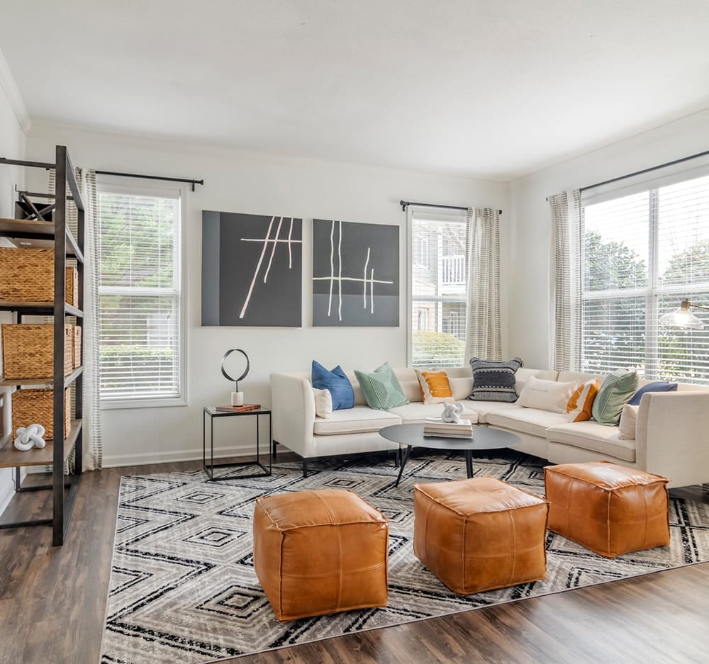 White living area with sectional couch and orange ottomans