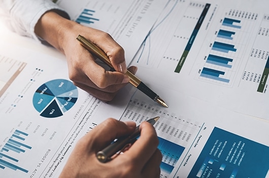 bell corporate plan 2020 2 hands holding pens point at paperwork