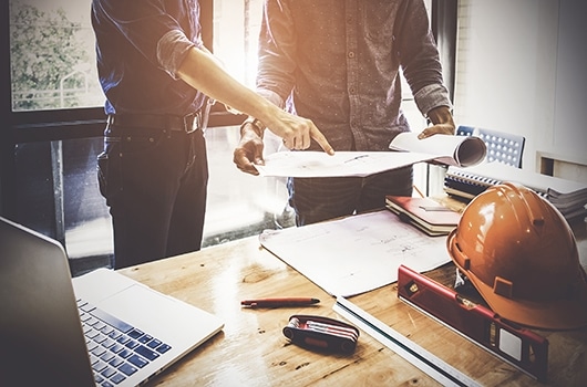 bell corporate plan 2020 Two men look over a blueprint